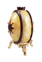 Souvenir egg made of two-color amber plates on a stand